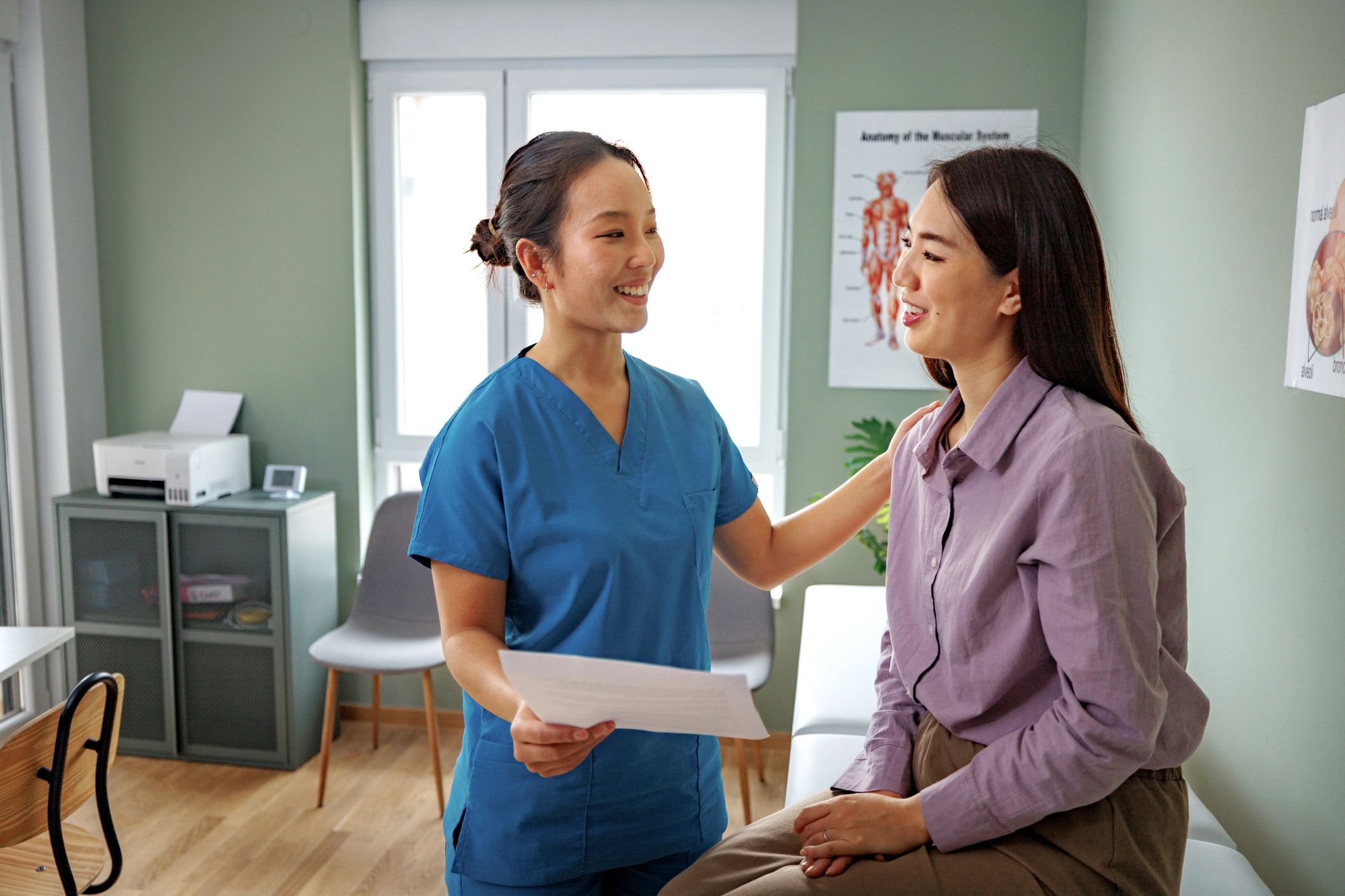 Asian medical professional consulting with a patient in a clinic office
